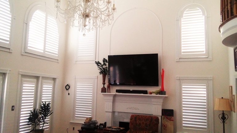 Houston great room with wall-mounted television and high-ceiling windows.